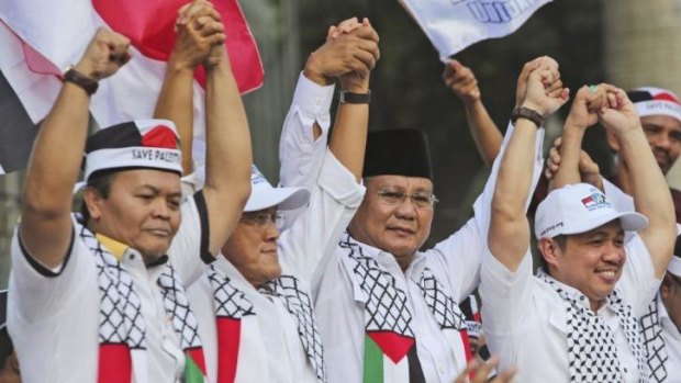 Indonesian presidential candidate Prabowo Subianto, second from right, holds hands with top members of his coalition party at a rally in Jakarta on Friday.