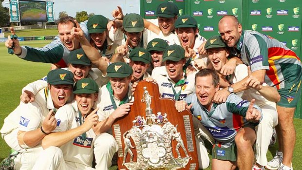 The Tasmanian Tigers team celebrate with the 2011 Sheffield Shield.