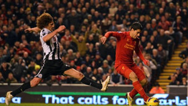 Out of reach: Liverpool striker Luis Suarez (right) beats defender Fabricio Coloccini on Sunday.
