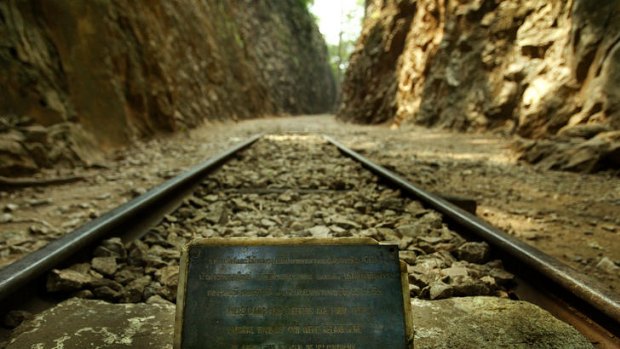 A Remeberance memorial plaque sits between railway tracks at the site of the infamous Burma Death Railroad.