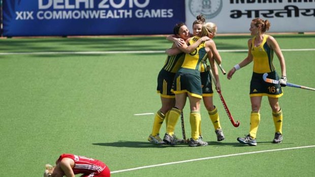Contrasting fortunes . . . Australian players celebrate as England's Natalie Seymour slumps on the field following the Hockeyroos' 1-0 victory.