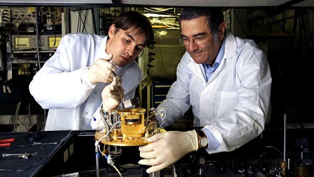 French physicist Serge Haroche, right, and his aid Igor Dotsenko examine a "photon trap".