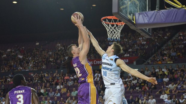 The air up there: Sydney's Angus Brandt attempts a dunk over Tom Abercrombie.