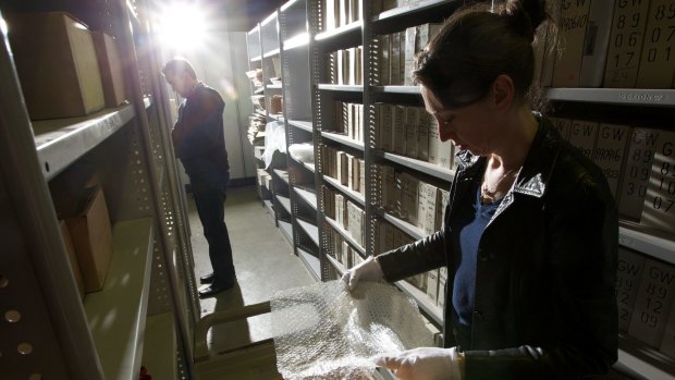 Fairfax librarian Ellen Fitzgerald and director of information services Chris Berry pack glass negatives at the Fairfax archives in Alexandria in 2012.