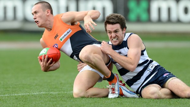 Giant tackle: Cat Jesse Stringer brings Tom Scully to his knees.