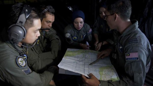 A Royal Malaysian Air Force Navigator captain talks with his team members during a search and rescue operation to find the missing Malaysia Airlines flight MH370.