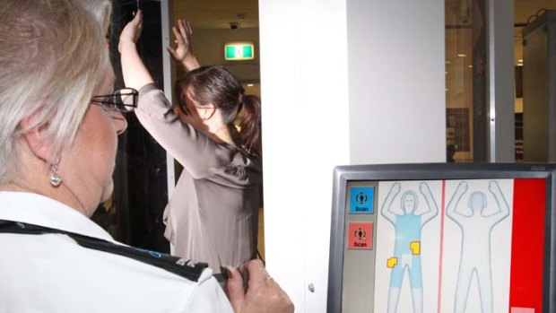 Less private &#8230; a passenger is scanned at Sydney International Airport.