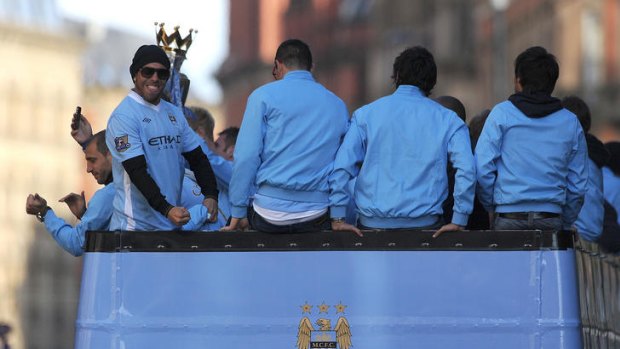 Celebration ...  Carlos Tevez takes part in a victory parade around the streets of Manchester.