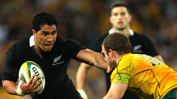 Trouble with rush defence ... Mils Muliaina of the All Blacks attempts to fend off Pat McCabe of the Wallabies.