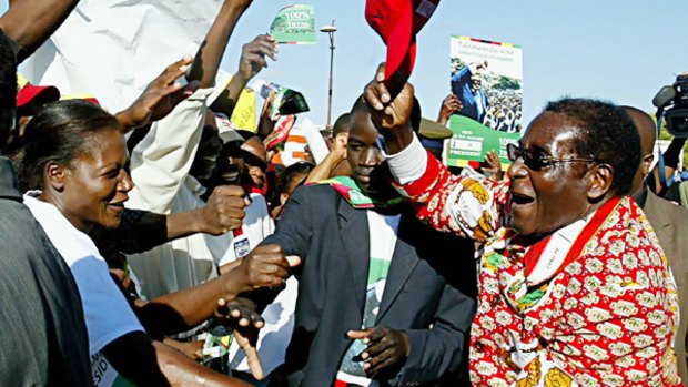 Zimbabwe President Robert Mugabe greeting supporters at White City Stadium, Bulawayo, says "only God could remove him from office".