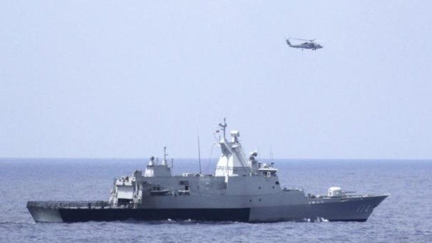 The Royal Malaysian Navy corvette KD Terengganu and a US Navy helicopter conduct a coordinated air and sea search for a missing Malaysian Airlines jet in the Gulf of Thailand. 