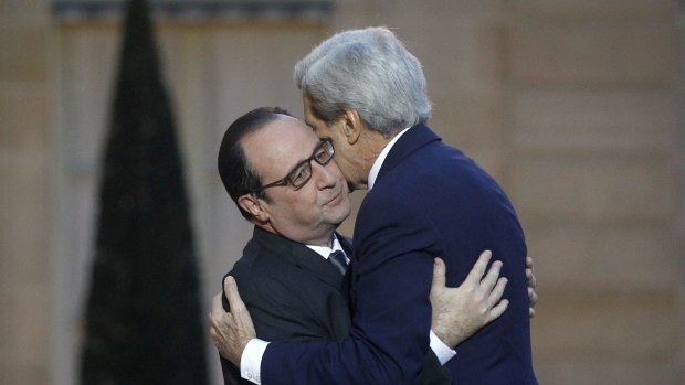 Hug it out: French President Francois Hollande welcomes US Secretary of State John Kerry.