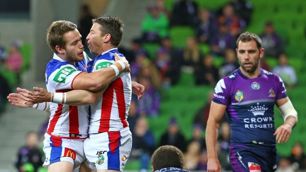 Kurt Gidley of the Newcastle Knights  after scoring a try as Cameron Smith of the Melbourne Storm looks on during at AAMI Park on Monday night.
