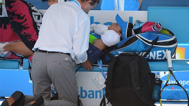 Zheng Jie's blood pressure is checked while she is treated for a heat-related illness during a medical time-out in her match against Casey Dellacqua.