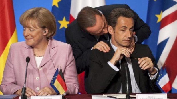 Silvio Berlusconi of Italy has a word in Nicolas Sarkozy's ear during a meeting of European leaders in Paris to discuss the global financial crisis in October 2008.