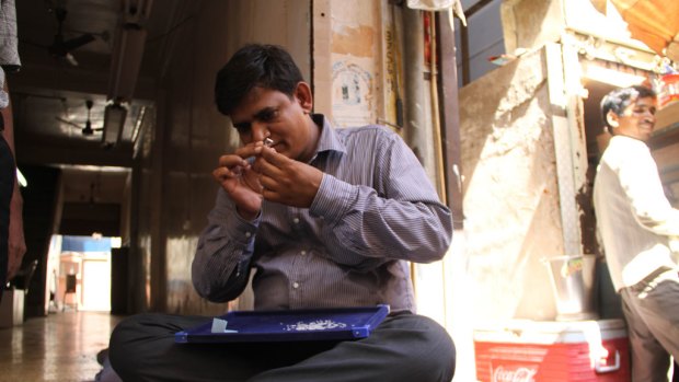 Few questions asked ... a Surat diamond trader, with his blue felt table in his lap, assesses the ‘‘maal’’, or product.