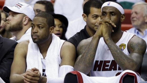 Apart now: Miami Heat forward LeBron James and guard Dwyane Wade sit on the bench during the NBA Finals.