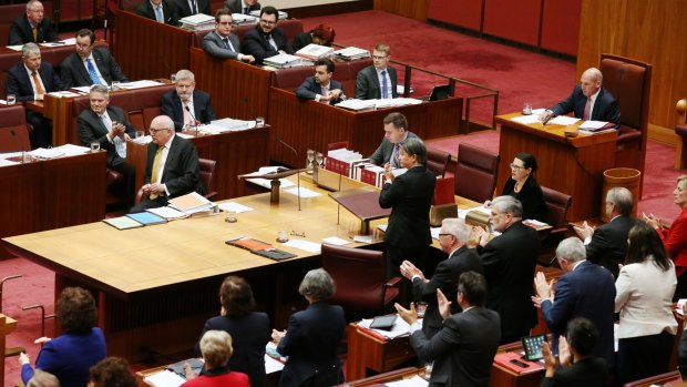 Labor senators give Attorney-General George Brandis an unprecedented standing ovation while his Coalition colleagues remain seated following his criticism of Pauline Hanson.