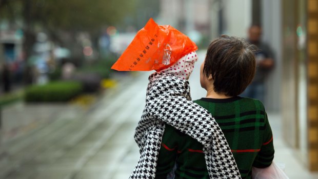 A woman carries a boy in Shanghai. China's one-child policy has led to a gender imbalance with there being fewer females to males.