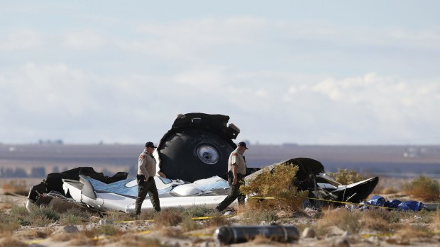 Mid-air breakup: Sheriff's deputies look at a piece of debris near the crash site of Virgin Galactic's SpaceShipTwo near Cantil, California. 