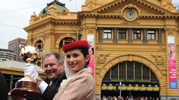 Lord Mayor Robert Doyle holds the trophy aloft during the Melbourne Cup parade.