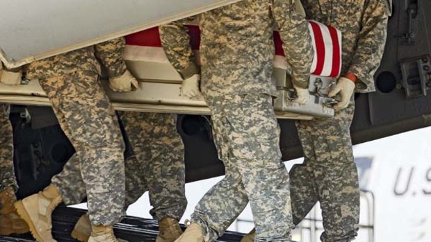Obama's war ... soldiers carry the remains of a comrade brought back to the US after he was killed in a helicopter crash in Afghanistan this week.