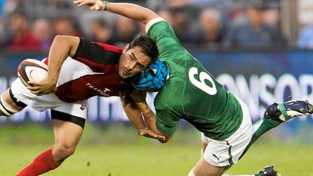 Canada's halfback Phil Mack  breaks a tackle from Ireland's flanker Kevin McLaughlin.