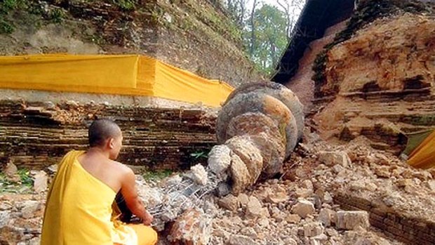 A Thai Buddhist monk inspects a shrine destroyed in the quake