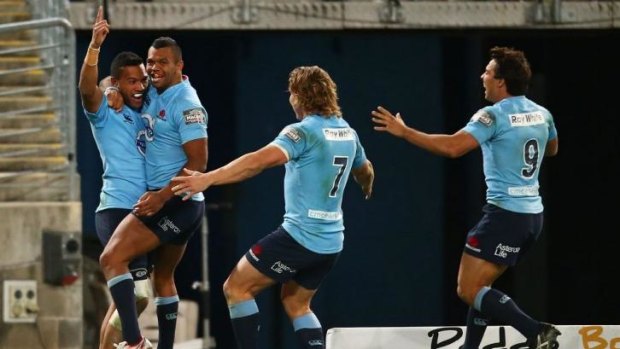 You beauty: Alofa Alofa is swamped by Waratahs teammates after scoring against the Brumbies.