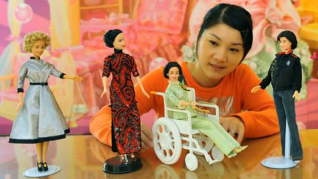A woman admires Barbie dolls at the Meining workshop.
