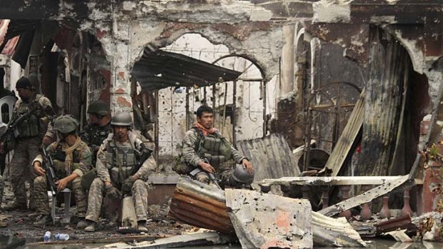 Victory: Troops rest amidst the ruins in Zamboanga.