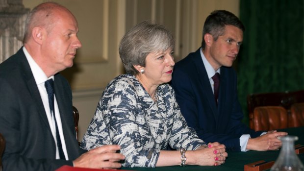 Theresa May sits with First Secretary of State Damian Green, left, and Government Chief Whip Gavin Williamson.