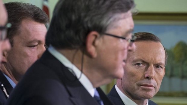 Prime Minister Tony Abbott watches as ASIO chief David Irvine explains the increase in terror threat level.