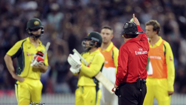 Umpire Ian Gould raises his finger after a video review of a caught and bowled appeal by New Zealand's Matt Henry of Australia's Mitchell Marsh.