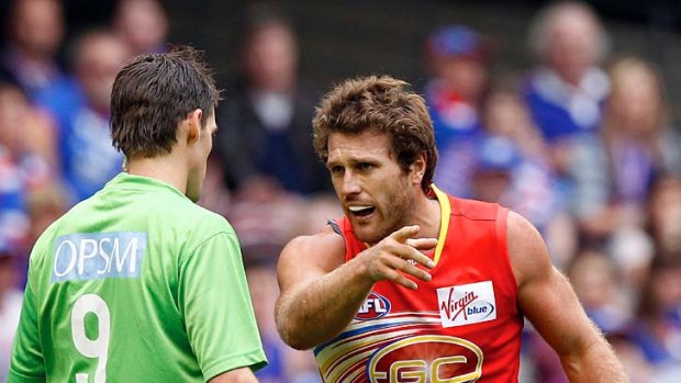 The emergency umpire speaks to Suns defender Campbell Brown after he was involved in an off the ball incident with Bulldogs midfielder Callan Ward.