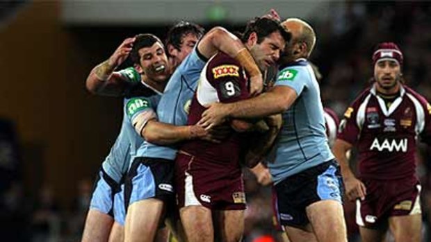 Maroons hooker Cameron Smith is mobbed in Queensland's disappointing defeat in game three last year.