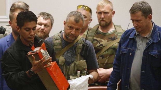 A Malaysian expert examines the MH17 black box after receiving it from pro-Russian rebels.