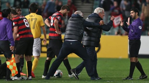 Marcello Lippi has to be held back after his side received their second red card.