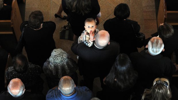 A child is the only one who spots <i>Age</i> photographer Mal Fairclough up above during the Easter Service at Our Lady of Lebanon Maronite Catholic Church.