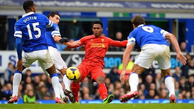 Liverpool's English striker Daniel Sturridge (2R) is tackled by Everton's French defender Sylvain Distin (L) and Everton's English midfielder Gareth Barry (2L).