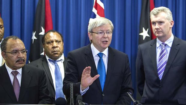 Papua New Guinea's Prime Minister Peter O'Neill and Australian Prime Minister Kevin Rudd sign an agreement over asylum seekers.