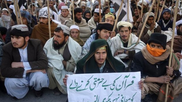 A supporter of the Jamaat-ud-Dawa Islamic organisation holds a placard while taking part in an anti-US rally in Quetta.
