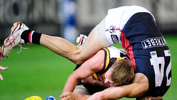 Head first: Hawthorn's Sam Mitchell goes in low against St Kilda's Sean Dempster on Saturday night.