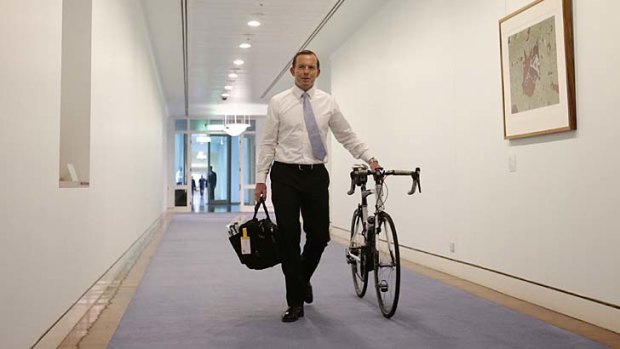 Man on a mission: Prime Minister-elect Tony Abbott wheels his bicycle from his old office to his Prime Ministerial office at Parliament House on Monday.