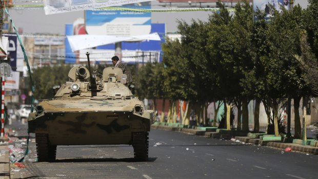 A Houthi fighter sits in a tank belonging to Houthi fighters on a street leading to the Presidential Palace during clashes in Sanaa.