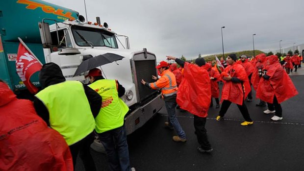 Body on the line ... A worker jumps in front of a truck in a bid to stop it crossing the picket line at Somerton yesterday.