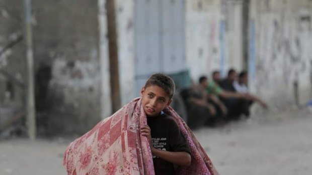 A Palestinian boy flees his house in Jebaliya refugee camp in the northern Gaza Strip on Tuesday.