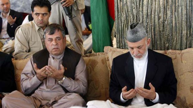 Afghan President Hamid Karzai (right) and Kandahar governor Toryalai Wesaw pray during a visit by the President to the Arghandab district of Kandahar.