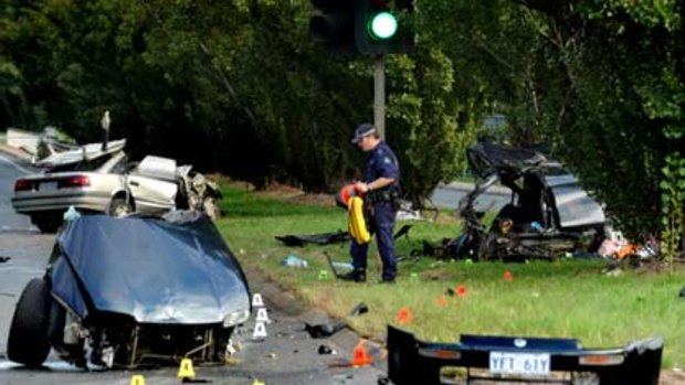 Forensic teams examine the scene of a crash after a police pursuit of a stolen car, in which four people died including a baby.