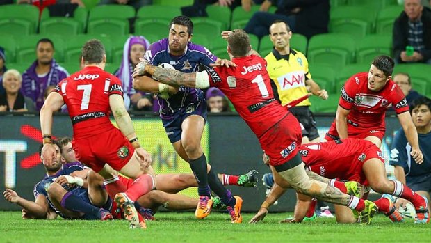 Young Tonumaipea of the Storm breaks through a tackle by Josh Dugan of the Dragons en route to scoring the match-winning try on Monday night.